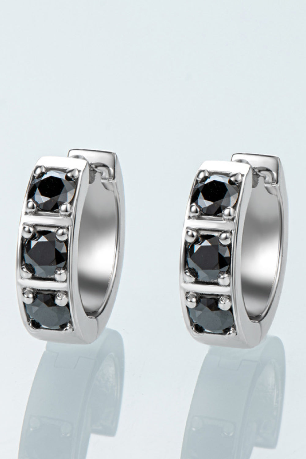Silberne Creolen mit schwarzen Zirkonia-Steinen, eleganter Schmuck, modische Ohrringe.