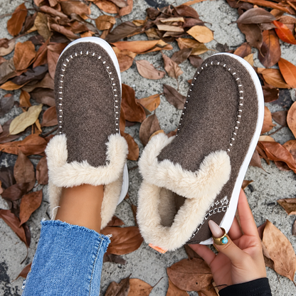 Braune Slip-On-Sneaker von oben, einer getragen, einer in der Hand mit sichtbarem weichem Plüschfutter im Inneren. 8