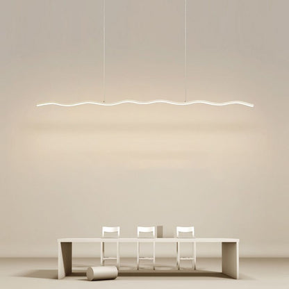 Moderne LED-Pendelleuchte, wellenförmig, über minimalistischem Esstisch mit weißen Stühlen.