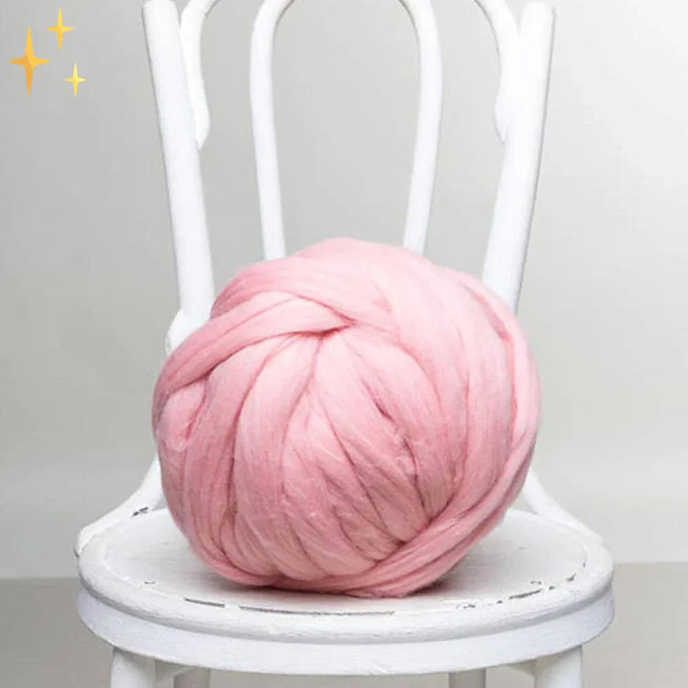 Rosa XXL-Strickgarn aus Wolle auf weißem Stuhl, ideal für DIY-Projekte und Dekoration.
