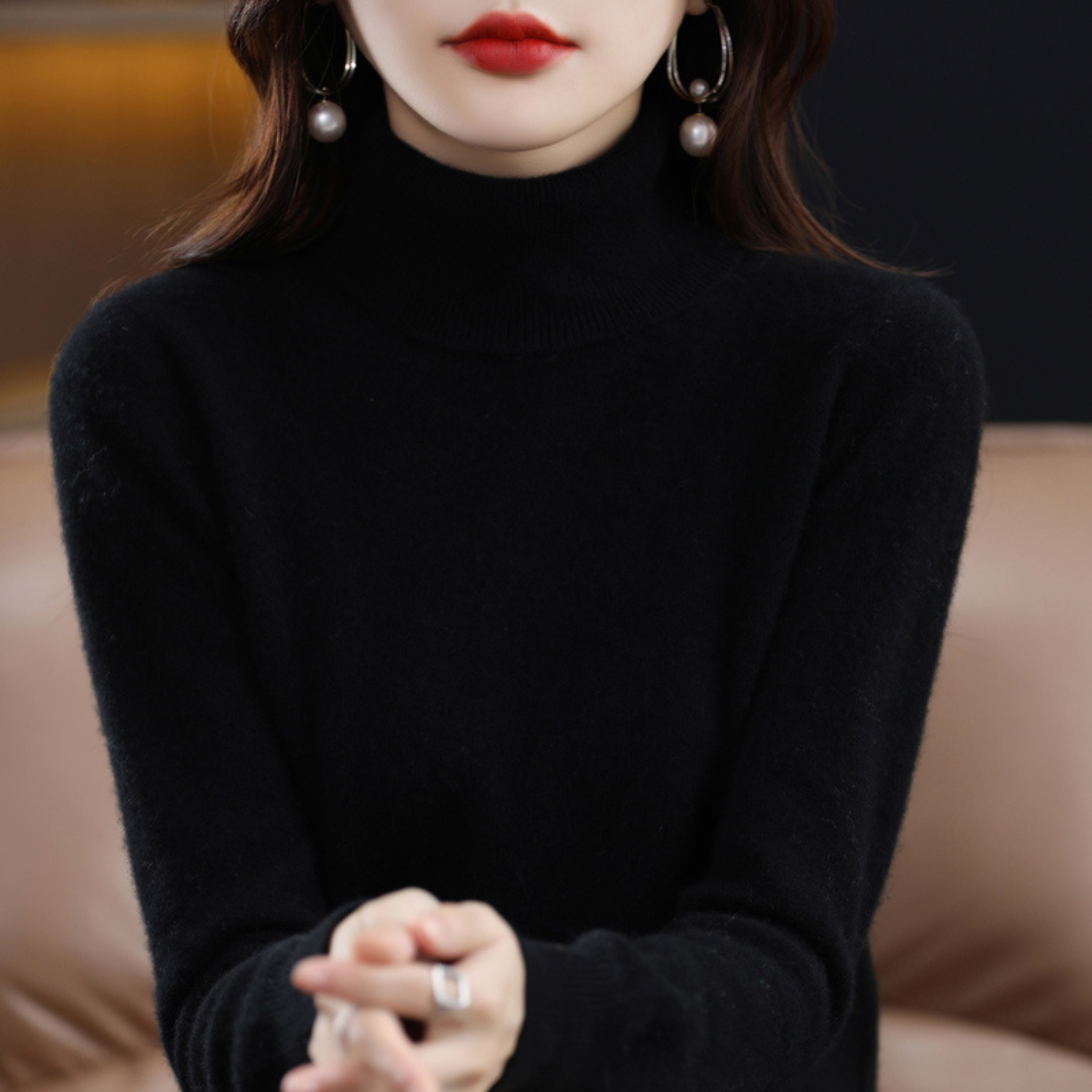 Frau in schwarzem Rollkragenpullover, elegante Ohrringe, roter Lippenstift, stilvolle Mode.