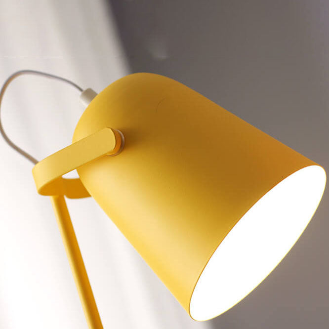 Nahaufnahme des gelben, eimerförmigen Lampenschirms mit Haltearm und weißem Kabel, von unten leuchtet das helle Licht heraus. 2