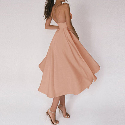 Frau in elegantem, pfirsichfarbenem Sommerkleid mit Spaghettiträgern und Sandaletten.