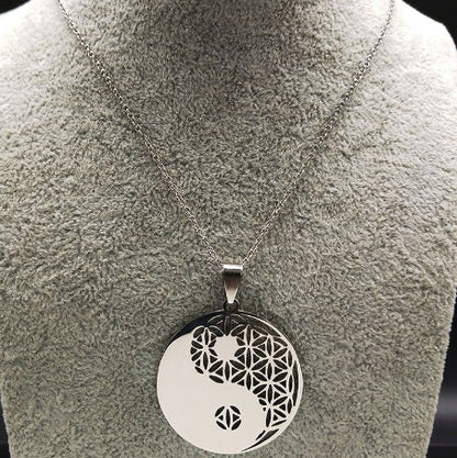 Yin-Yang-Anhänger aus Edelstahl mit filigranem Muster auf silberner Kette, Schmuckdisplay.
