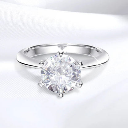 Silberner Verlobungsring mit großem, rundem Diamant auf weißem Hintergrund.