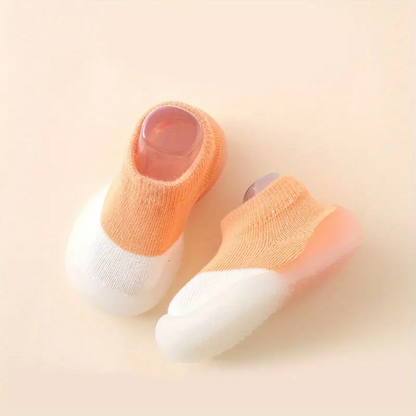 Orange-weiße Babyschuhe, rutschfest, weiche Sohle, Strickmaterial, ideal für Kleinkinder.