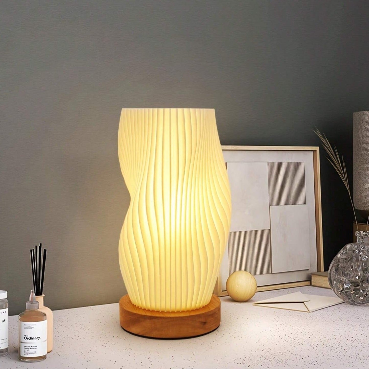 Moderne Tischlampe aus Holz mit wellenförmigem Design, warmes Licht, ideal für Wohnzimmer.