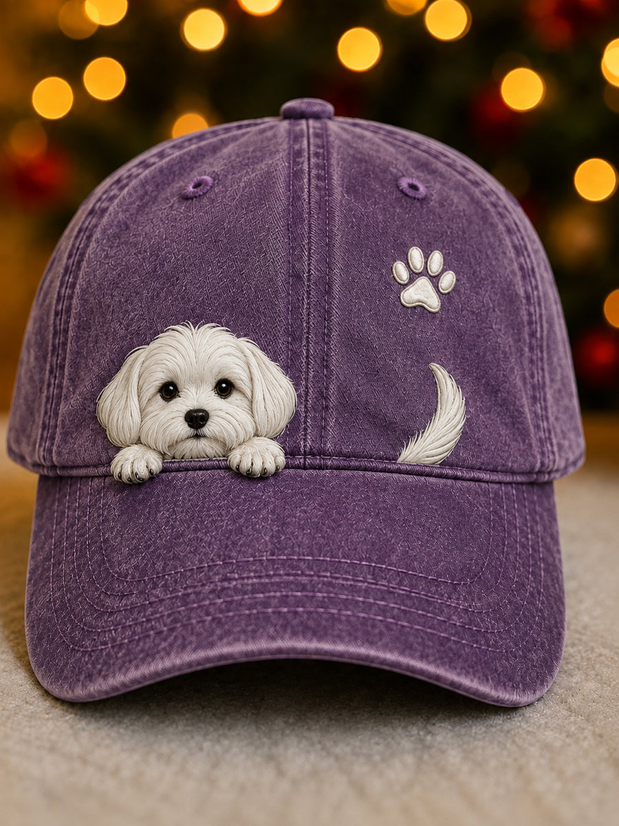 Frontansicht der violetten Kappe mit gewaschener Oberfläche, weißem Hundewelpen, Pfotenabdruck und Rute vor weihnachtlichem Bokeh. 7