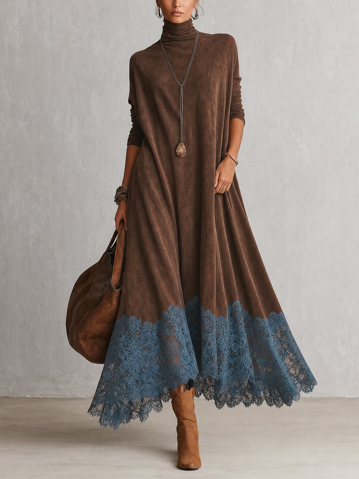 Model in braunem Rollkragenkleid mit blauem Spitzensaum, dazu Cowboystiefel und große Ledertasche, Ganzkörperansicht von 1