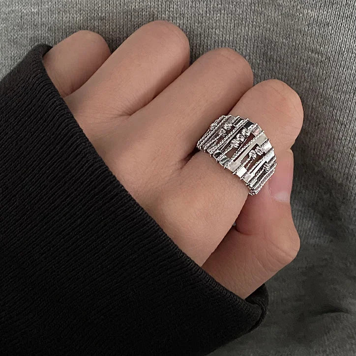 Silberner Ring mit geometrischem Design auf Hand, moderner Schmuck, Unisex, stilvoll, elegant.