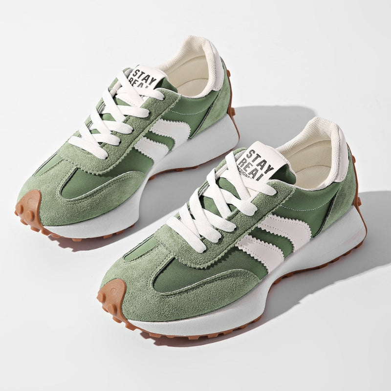 Paar grüne Wildleder-Sneaker mit weißen Streifen und heller Sohle, schräg von oben vor weißem Hintergrund 1