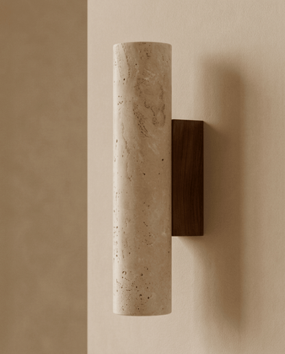 Seitenansicht der zylindrischen Travertin-Wandlampe mit dunkler Wandhalterung aus Holz vor beiger Wand 1