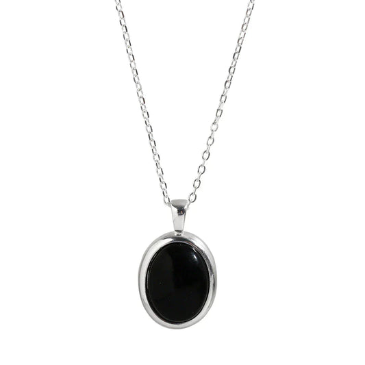 Silberkette mit ovalem schwarzem Anhänger, eleganter Schmuck, Damenaccessoire.