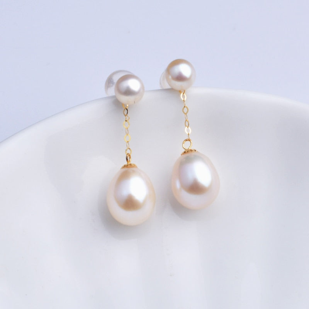 Perlenohrringe mit goldener Kette, Tropfenform, eleganter Schmuck, weiß, Damenaccessoire.