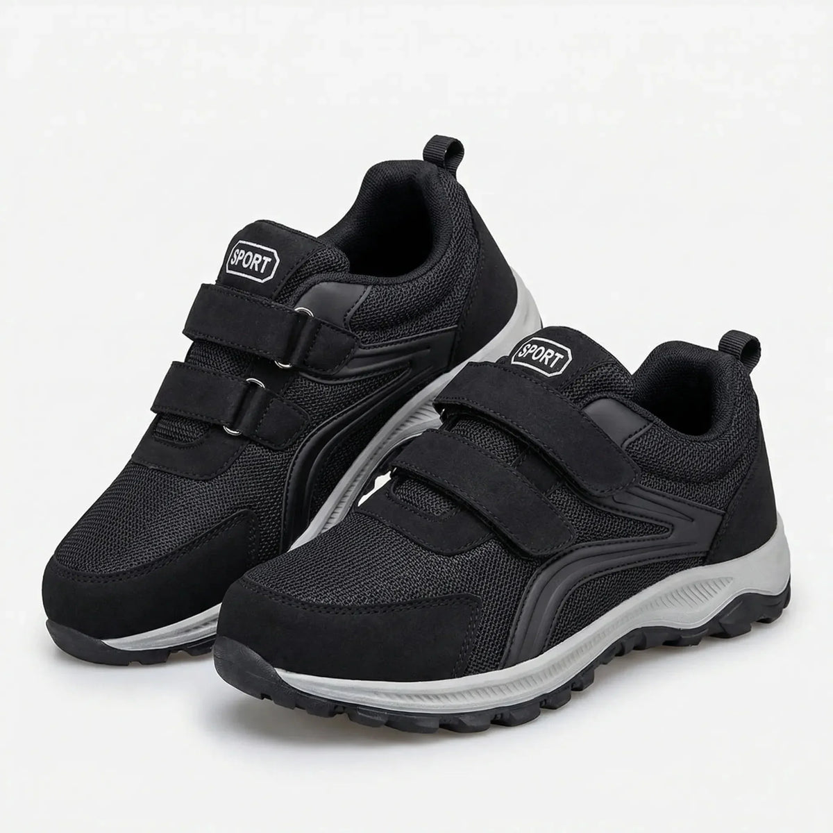 Paar schwarze Klettschuhe mit zwei Riemen und grauer Sohle schräg vor hellem Hintergrund 5