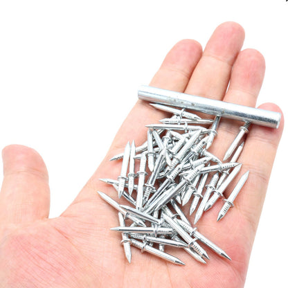 Handvoll silberfarbener Doppelspitzen-Nägel mit Bund und Rillen, daneben das zylindrische Metall-Hülsenwerkzeug, auf einer offenen Handfläche. 1