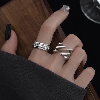 Silberringe an Hand, geometrisches Design, Damenmode, Schmuckaccessoire, stilvoll, modern.