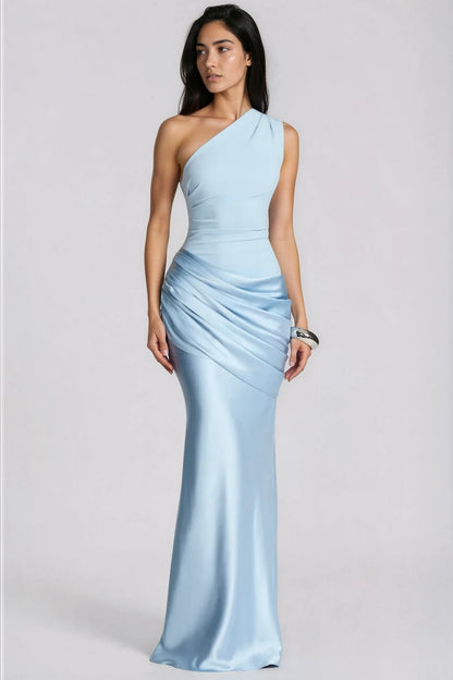 Model in hellblauem Maxikleid mit einer Schulter und gerafftem Satinrock, leicht zur Seite blickend, silberner Armreif, Ganzkörperansicht. 1