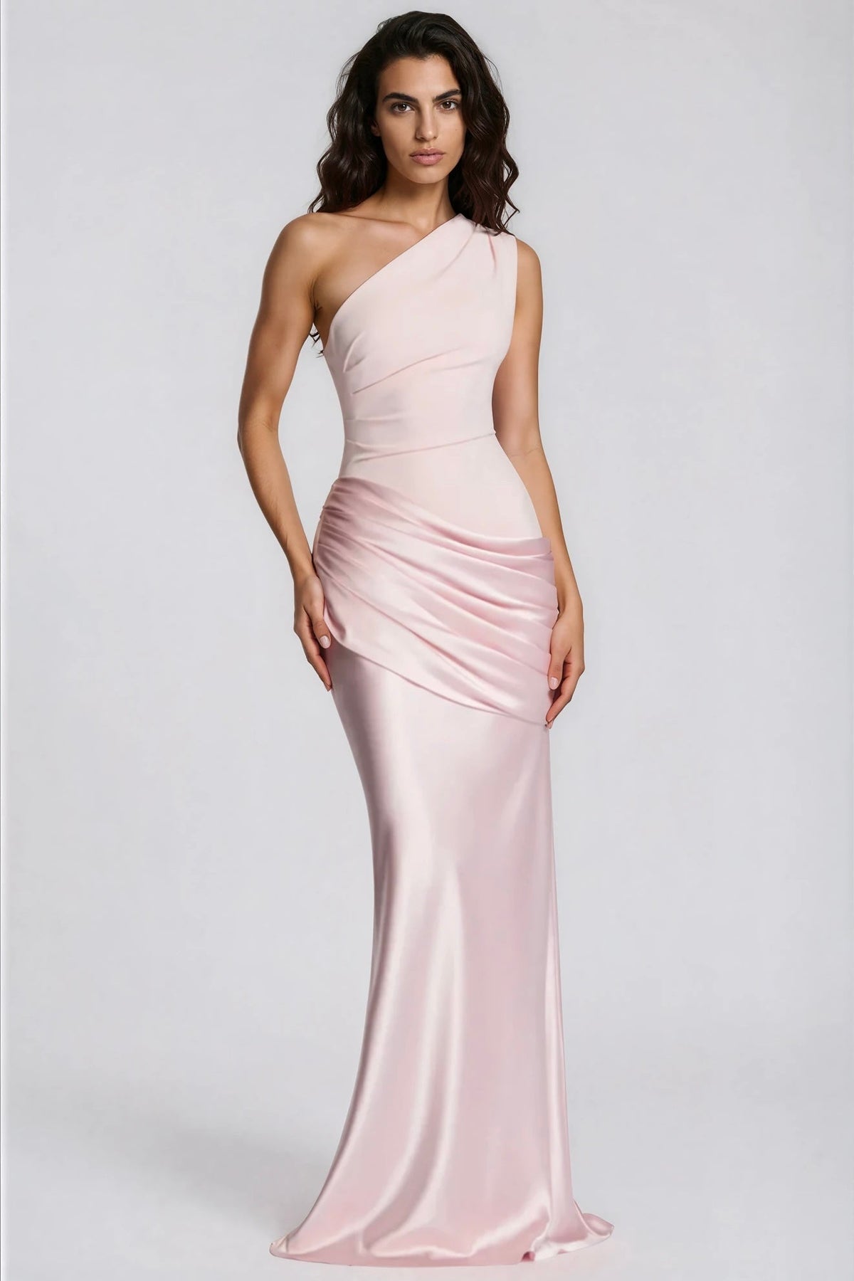 Model in zartrosa Einschulterkleid mit gerafftem Hüftteil und glänzendem Satinrock, Frontansicht vor grauem Hintergrund. 30