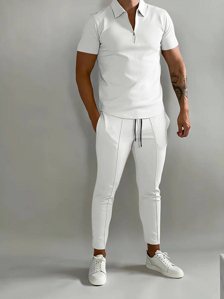 Mann in weißem Poloshirt und Jogginghose, sportlich-eleganter Look, Freizeitmode.