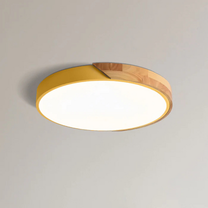 Gelbe flache Aufbauleuchte mit Holzsegment, freigestellt von schräg unten an einer hellen Decke 14