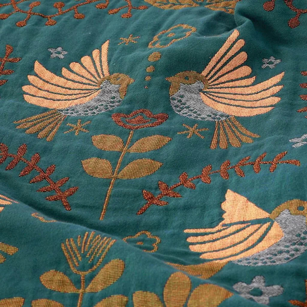Grüner Stoff mit gestickten Vögeln und Blumen, handgefertigt, dekorativer Textilkunststoff.