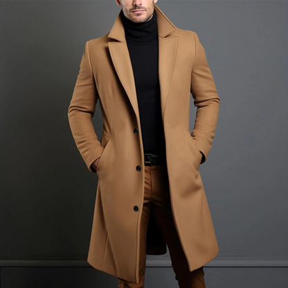 Der lange Mantel in Kamelbraun an einem Model, vorne geknöpft, mit Reverskragen, kombiniert mit schwarzem Rollkragenpullover. 2
