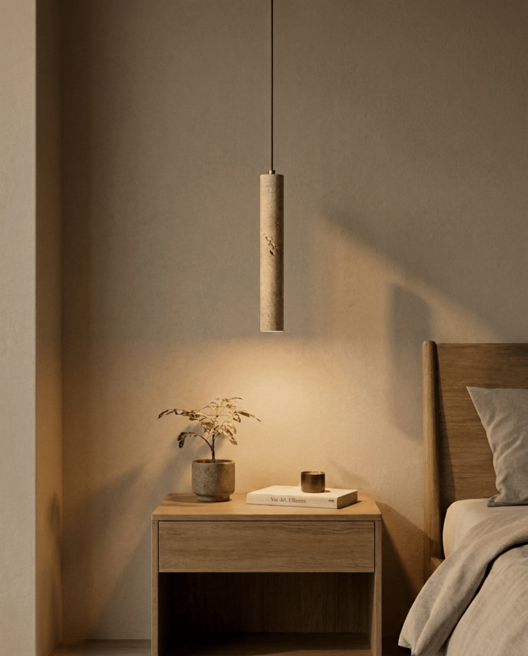 Dieselbe Pendelleuchte eingeschaltet im Schlafzimmer, warmes Licht fällt auf Nachttisch, Pflanze und Wand 2