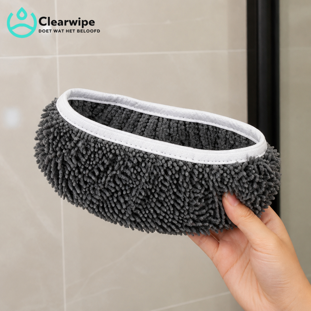 Hand hält ein graues Chenille-Pad mit weißem Elastikrand vor einer hellen Fliesenwand, Detailaufnahme der Fransen. 4