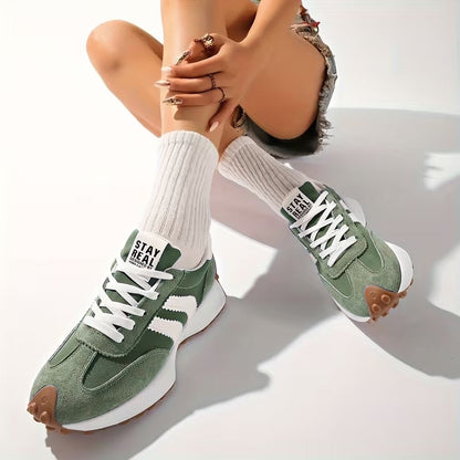 Grüne Sneaker mit weißen Streifen, getragen zu weißen Rippensocken, Model sitzt mit angezogenen Beinen 7