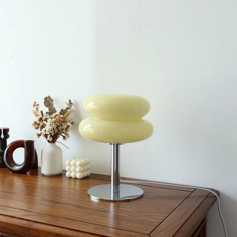 Gelbe Tischlampe aus Glas auf Holztisch, moderne Inneneinrichtung, minimalistisch, Wohnzimmer.