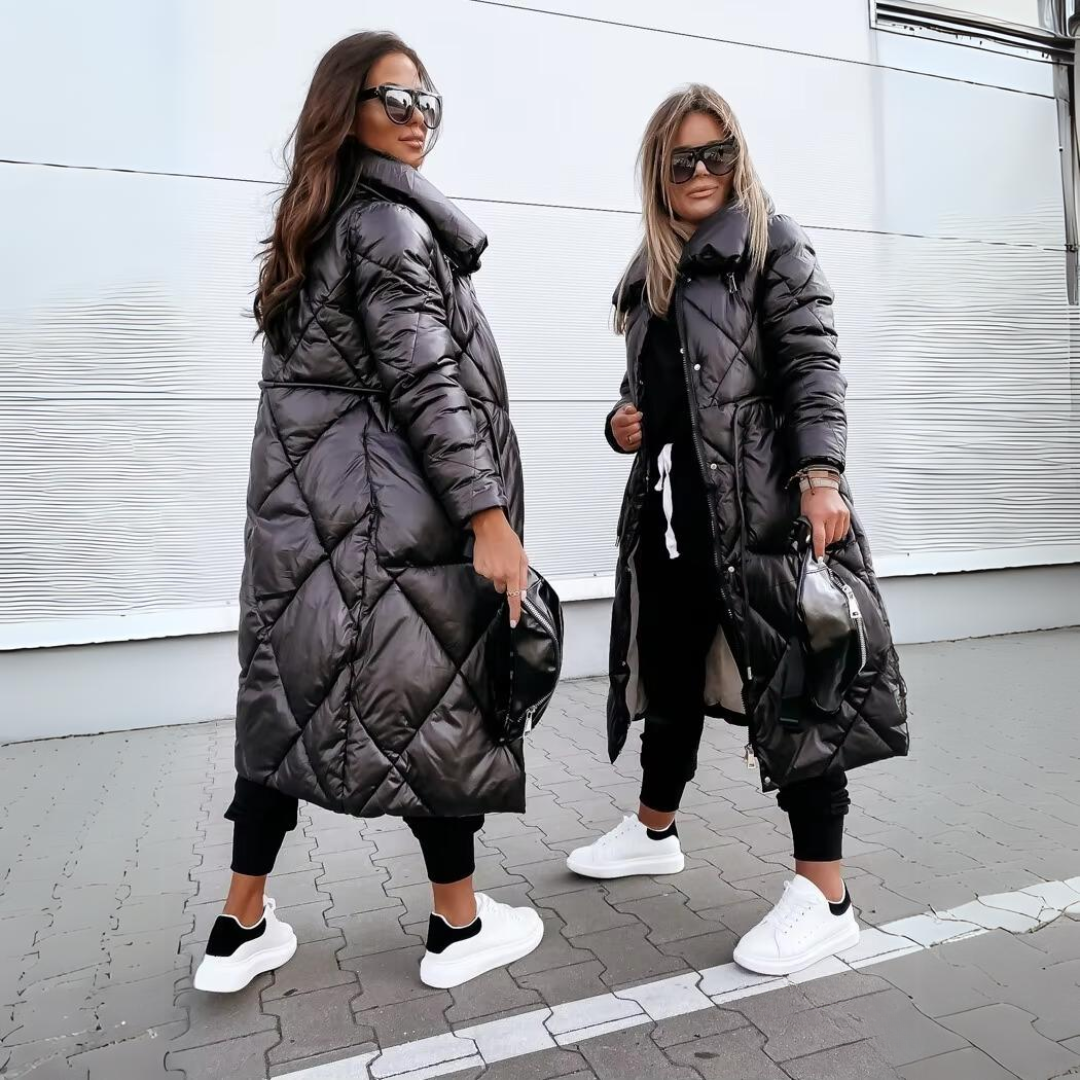 Zwei Frauen mit Sonnenbrillen zeigen den schwarzen Steppmantel von der Seite und von vorne, kombiniert mit weißen Sneakern. 4