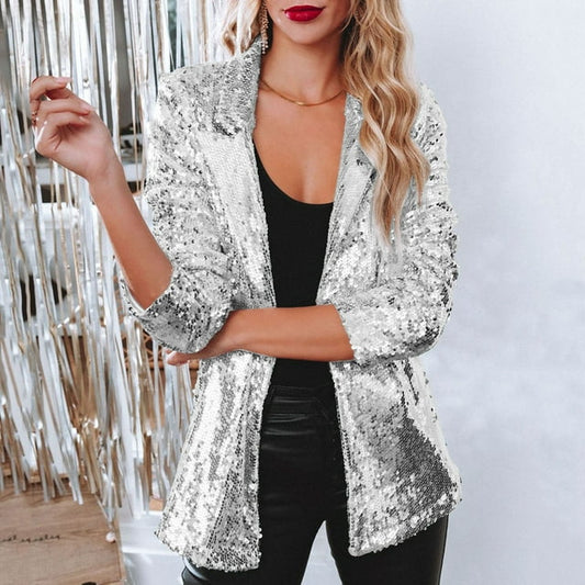 Frau in silbernem Paillettenblazer, schwarzem Top und Lederhose, glamouröses Party-Outfit.