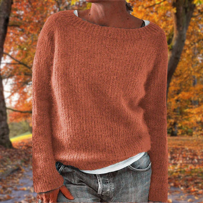 Rostroter Strickpullover mit lockerem Schnitt, getragen über weißem Shirt und grauer Jeans in einer Herbstlandschaft. 6