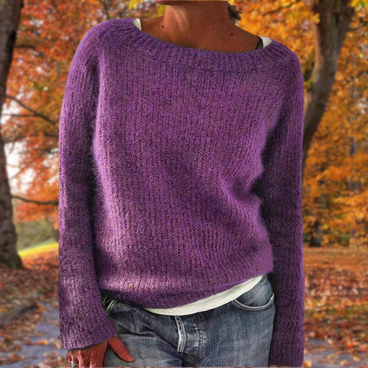 Violetter Strickpullover mit Rundhalsausschnitt, von einer Frau mit Jeans und weißem Shirt im herbstlichen Park getragen. 7