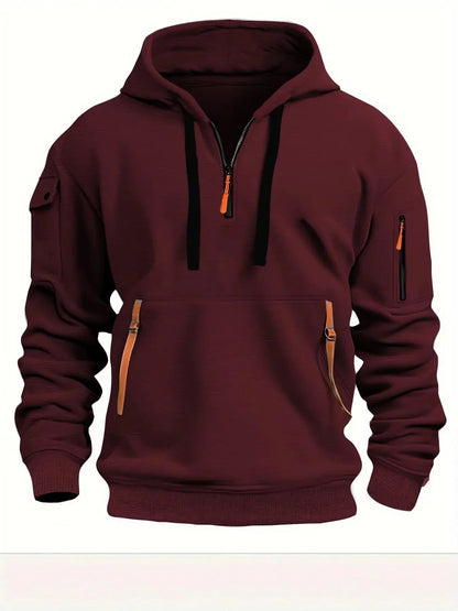 Weinroter Kapuzenpullover in der Vorderansicht mit schwarzen Kordeln, orangefarbenen Bändern an der Bauchtasche und Ärmeltasche mit Reißverschluss. 5