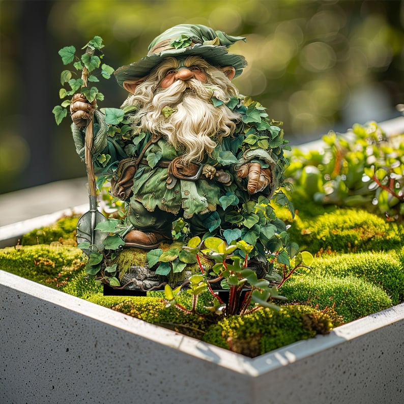 Gartenwichtel mit Spaten und Efeu steht in einem Betontrog mit Moos und kleinen Pflanzen. 15