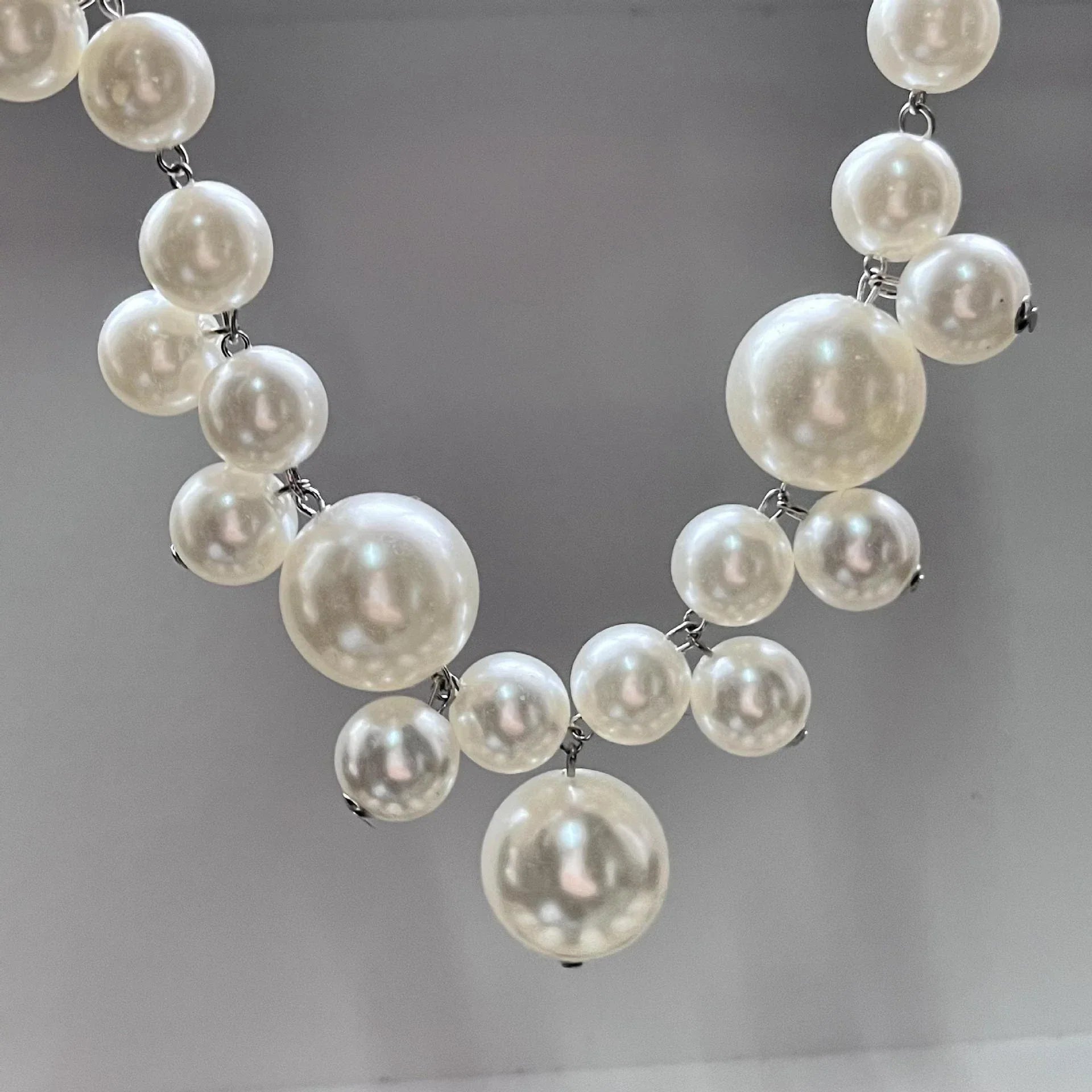 Perlenkette aus weißen Kunstperlen, elegantes Schmuckstück, modisches Accessoire für Damen.
