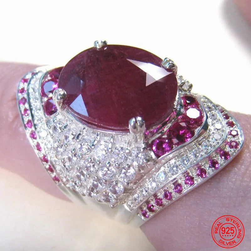 Silberring mit großem ovalem Rubin, umgeben von kleinen Diamanten und Rubinen, 925 Sterling.