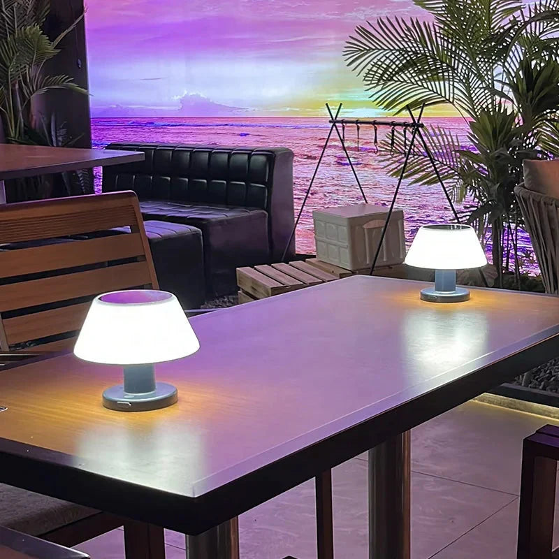 Moderne LED-Tischlampen auf Holztisch, Hintergrund mit tropischem Strandmotiv, Innenraum.