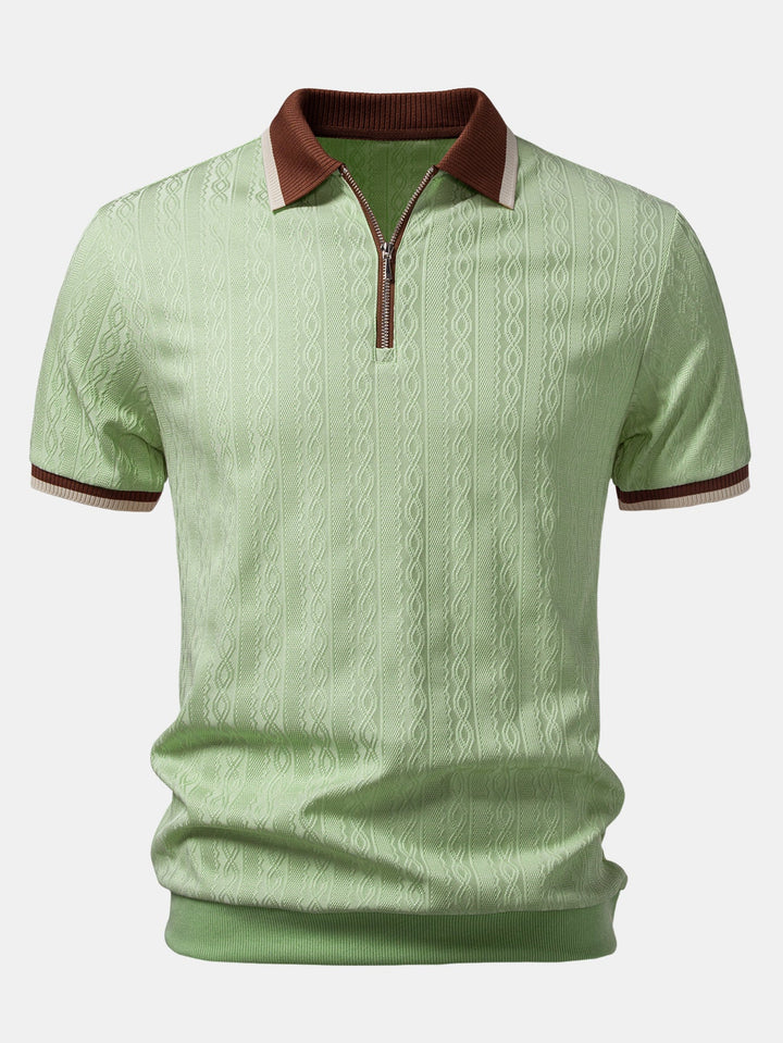 Vorderansicht des hellgrünen Poloshirts mit Zopfstruktur, braunem Rippkragen, Reißverschluss am Ausschnitt und gestreiften Ärmelbündchen. 7