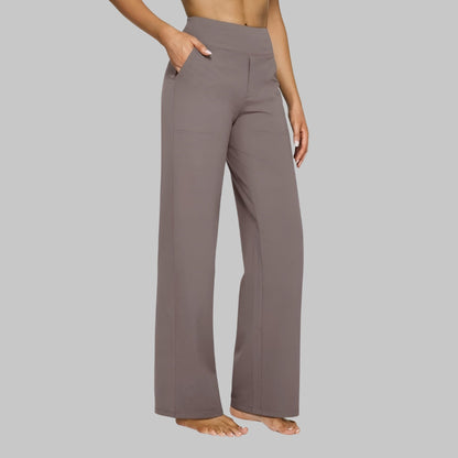 Seitenansicht der geraden Hose in Taupe an einer Frau, eine Hand in der Seitentasche, hoher breiter Bund. 1