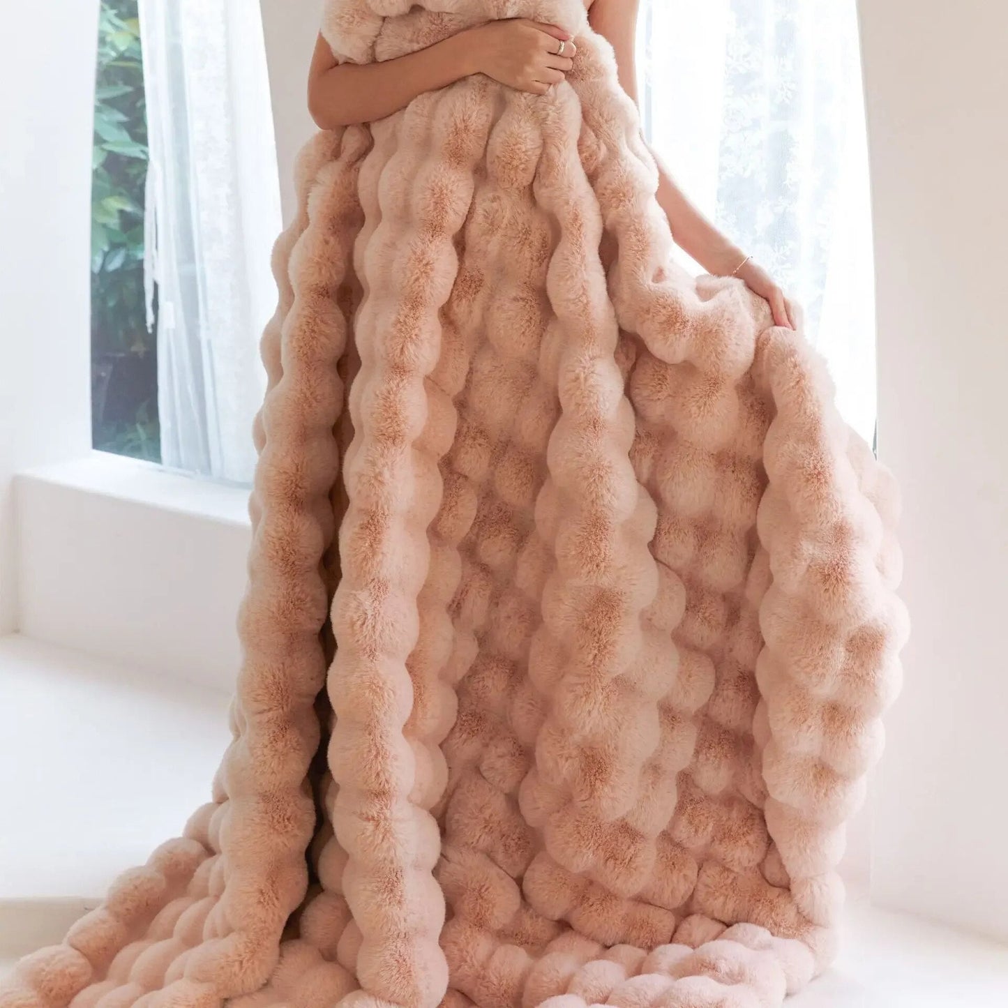 Flauschige rosa Decke, voluminös, luxuriös, weiches Material, ideal für gemütliche Wohnräume.