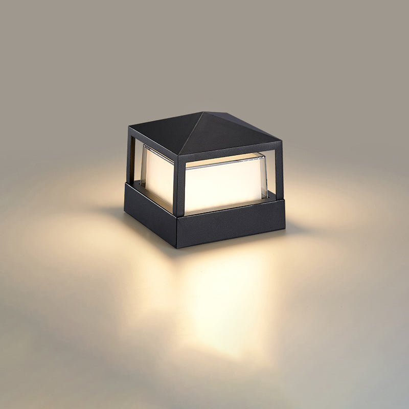 Quadratische schwarze Leuchte mit pyramidenförmigem Dach und warm leuchtendem Diffusor, freigestellt auf hellem Hintergrund. 10