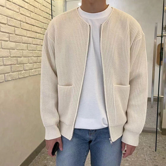 Mann in cremefarbener Strickjacke, weißem T-Shirt und Jeans, lässige Herrenmode.