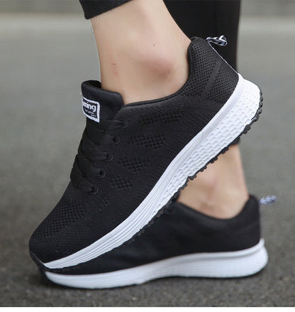 Schwarze Sportschuhe mit weißer Sohle, atmungsaktives Mesh, ideal für Laufen und Fitness.
