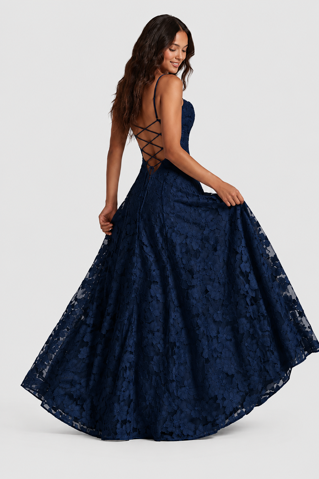 Marineblaues Spitzenkleid in Rückansicht, Model hält den Rock seitlich fest; offener Rücken mit gekreuzter Schnürung sichtbar. 5