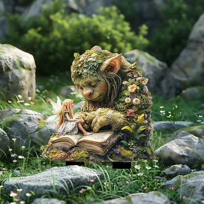 Bemooster Troll mit Fee auf seinem Buch, zwischen Felsen und Gras mit kleinen weißen Blüten aufgestellt. 12