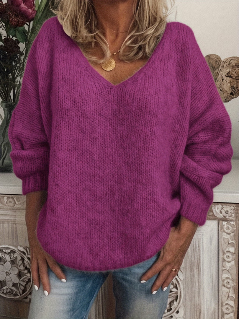 Grobstrickpullover in leuchtendem Violett-Pink, getragen zur Jeans, mit V-Ausschnitt, überschnittenen Schultern und weichem, leicht flauschigem Strick. 6
