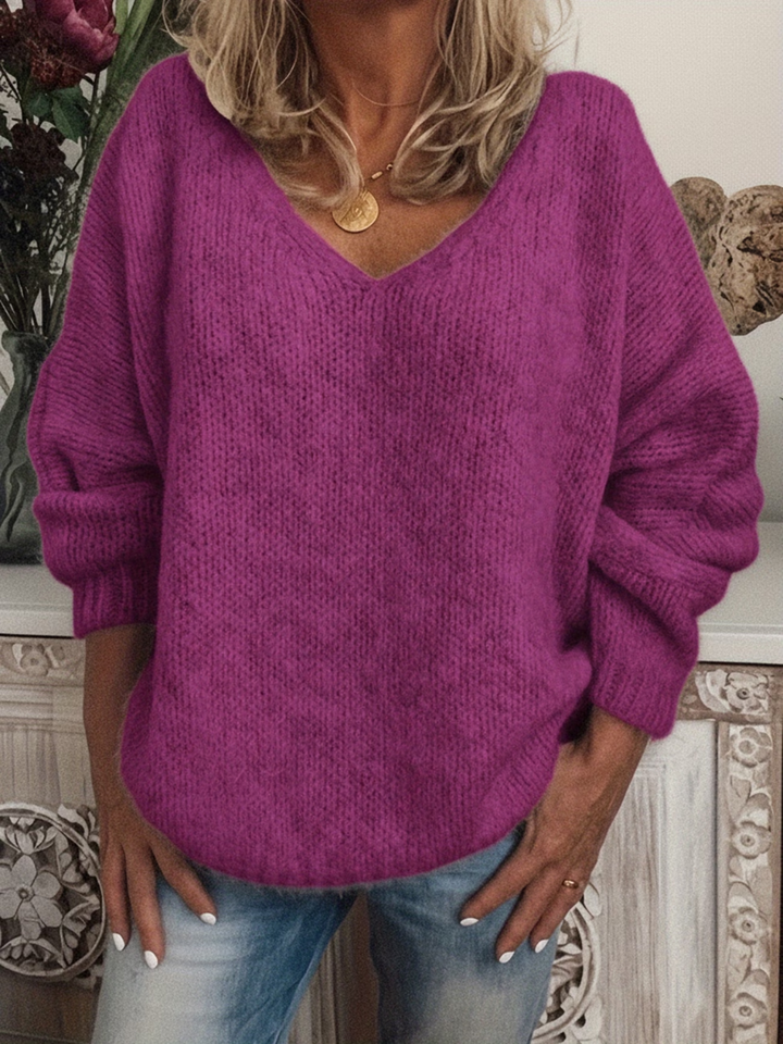 Grobstrickpullover in leuchtendem Violett-Pink, getragen zur Jeans, mit V-Ausschnitt, überschnittenen Schultern und weichem, leicht flauschigem Strick. 6
